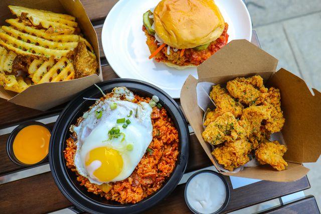 Kimchi Fried Rice ($12.99), Waffle Fries with Nacho Cheese sauce ($4.99), Classic Spicy Chicken Sandwich ($6.99), Nine-piece Poppers with Kuku Ranch ($6.99)